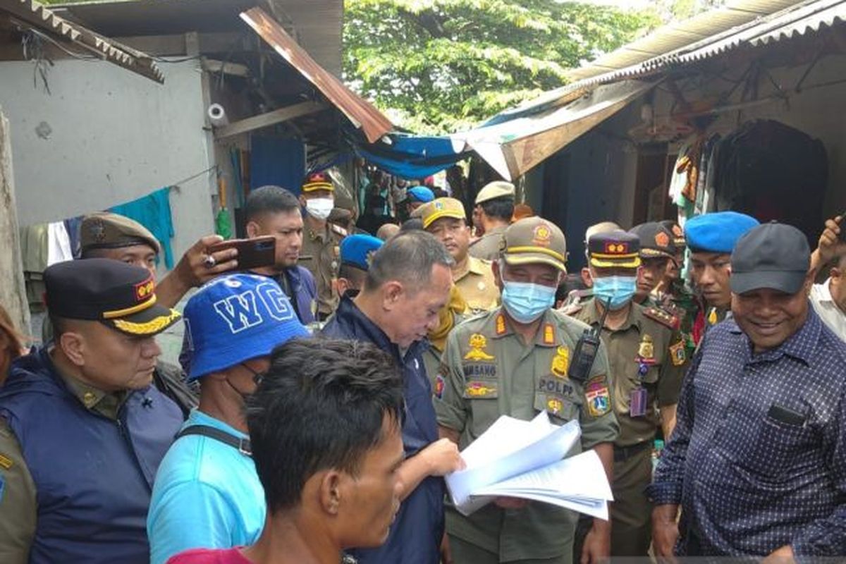 Petugas gabungan melayangkan surat peringatan kedua penertiban bangunan di bantaran Kali Ciliwung, Jakarta, Senin (9/1/2023). 