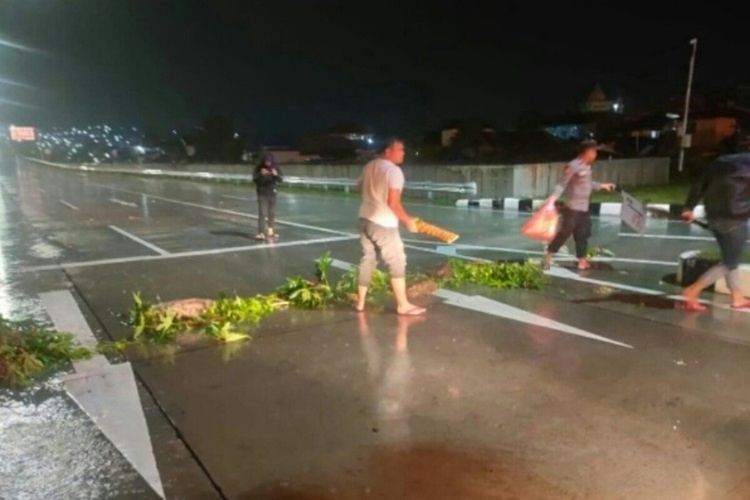 Personel Polres Bitung membuka akses jalan menuju pintu masuk Tol Bitung-Manado, yang sebelumnya diblokir oleh warga, Kamis (7/7/2022).