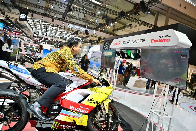 Seorang pengunjung mencoba simulator MotoGP resmi di booth Pertamina. Wahana ini menjadi salah satu daya tarik utama yang mengajak pengunjung merasakan sensasi balapan profesional secara virtual