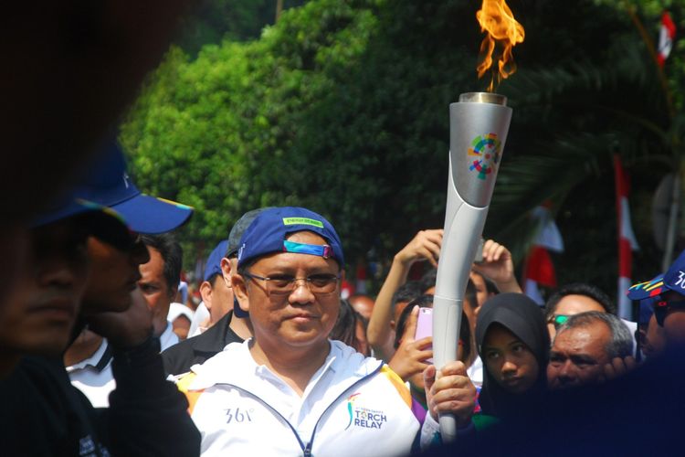 Menteri Komunikasi dan Informatika Rudiantara saat membawa obor dalam torch relay Asian Games 2018  yang berlangsung di Kota Bogor, Selasa (14/8/2018).