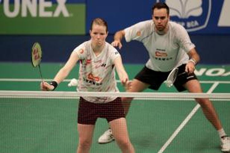 Pemain ganda campuran Denmark, Joachim Fisher Nielsen (belakang)/Christinna Pedersen, melakukan servis saat menghadapi ganda Tiongkok, Xu Chen/Ma Jin, pada final BCA Indonesia Open Superseries Premier, Minggu (22/6/2014). Fischer Nielsen/Pedersen menang 18-21, 21-16, 21-14.