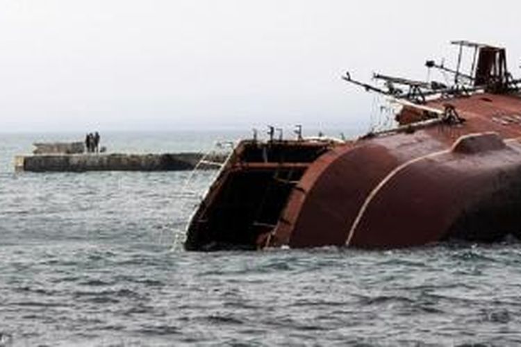 Sejumlah orang menonton saat kapal perang kapal anti-kapal selam Rusia, Ochakov, ditenggelamkan pada Kamis (6/3/2014) oleh pasukan Rusia di pantai Laut Hitam di luar kota Myrnyi, Crimea Barat.