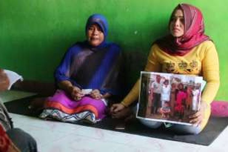 Halima (41) dan Gita (21), istri dan anak Agus Salim (51), nelayan yang menjadi korban penyanderaan kapal asing, memperlihatkan foto ayahnya saat ditemui di kediamannya.
