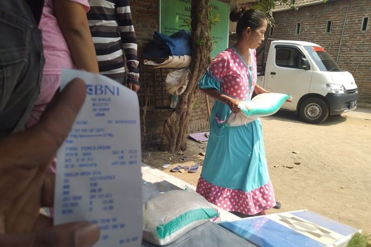 Salah satu KPM program Bantuan Pangan Non Tunai (BPNT) saat mengambil beras dari agen e-warong di Desa Kademangan, Kecamatan Mojoagung, Kabupaten Jombang, Jawa Timur, Kamis (26/9/2019).