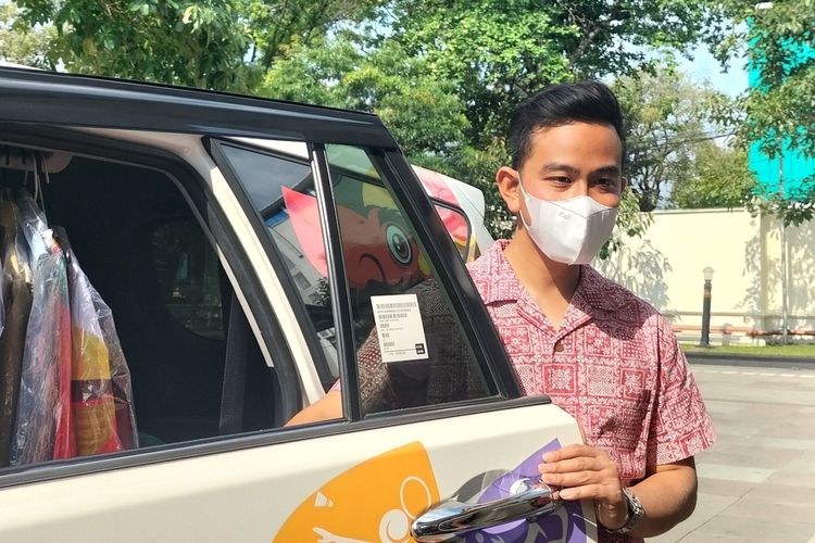 Wali Kota Solo Gibran Rakabuming Raka saat akan masuk ke mobil dinasnya Toyota Innova berwarna putih.