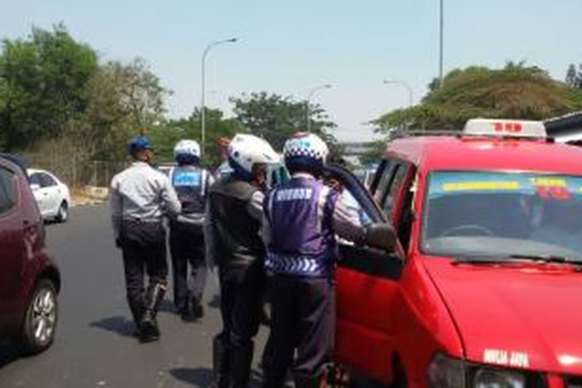 Petugas gabungan dari Dishub, polisi, dan TNI terhadap angkot yang ngetem di putaran balik arah Kampung Rambutan, Jakarta Timur.  Rabu (23/9/2015).