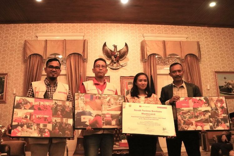 Director and Consumer Marketing Mastercard Kenny Winandari dan Executive Director Mercy Corps Indonesia Ade Soekadis secara simbolis menyerahkan bantuan kepada Asisten Pemerintahan dan Kesejahteraan Rakyat Sekretariat Daerah Kabupaten Cianjur Arief Purnawan pada Selasa (14/2/2023).