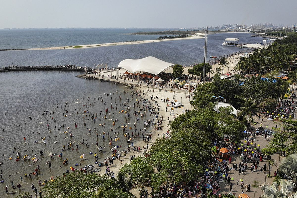 Foto aerial suasana pengunjung Pantai Karnaval Ancol, Jakarta, Kamis (6/6/2019). Hingga sore ini tercatat sekitar 100 ribu pengunjung memanfaatkan waktu libur Lebaran 2019 bersama keluarga di Taman Impian Jaya Ancol.