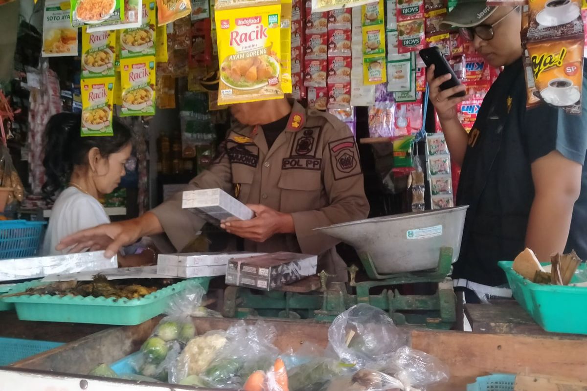 Satpol PP Lamongan saat melakukan razia rokok ilegal yang beredar dan diperjualbelikan di toko kelontong di Lamongan, Jawa Timur, Kamis (4/7/2024).