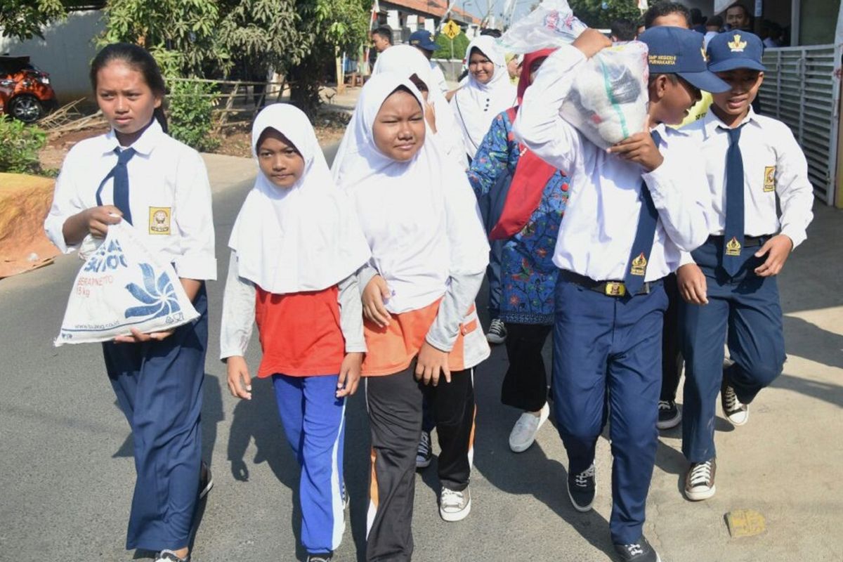 Pelajar SMPN 5 Purwakarta membagikan beras pada warga miskin yang tinggal di sekitar sekolah, Kamis (7/9/2017). Aksi sosial ini merupakan perwujudan program Kemis Poe Welas Asih.