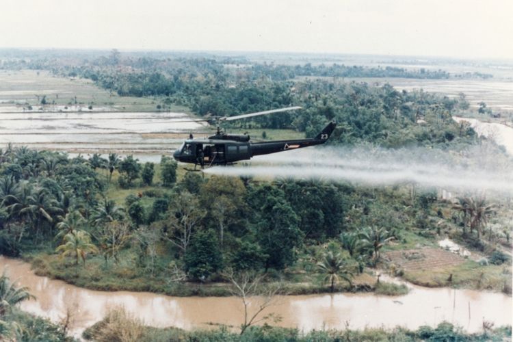 Helikopter Huey Angkatan Darat AS menyemprotkan Agent Orange ke lahan pertanian selama Perang Vietnam, 1 Januari 1963