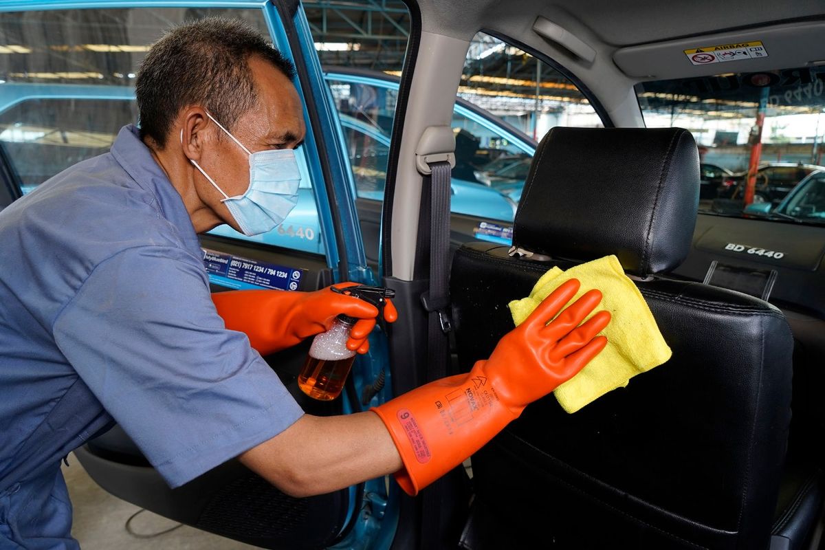 Ilustrasi petugas membersihkan taksi