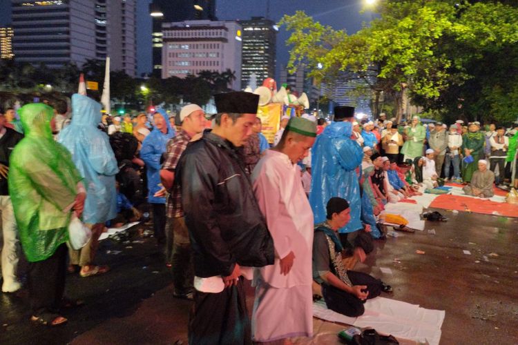 Massa Aksi 2309 tetap bertahan dan melaksanakan solat di tengah derasnya hujan, Jakarta Pusat, Jumat (23/9/2022)