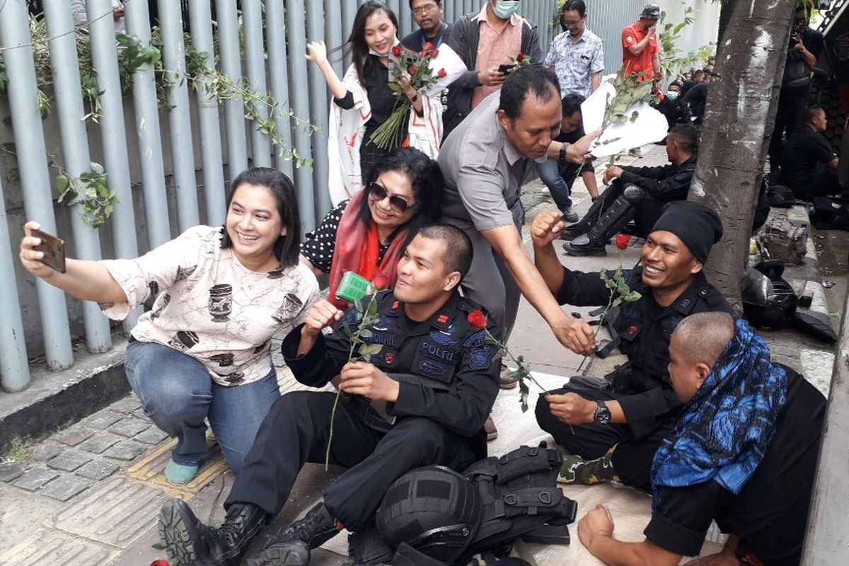 Warga memberikan bunga mawar kepada personil Brimob yang bertugas di Kantor Bawaslu RI, Jakarta Pusat, Kamis (23/5/2019).