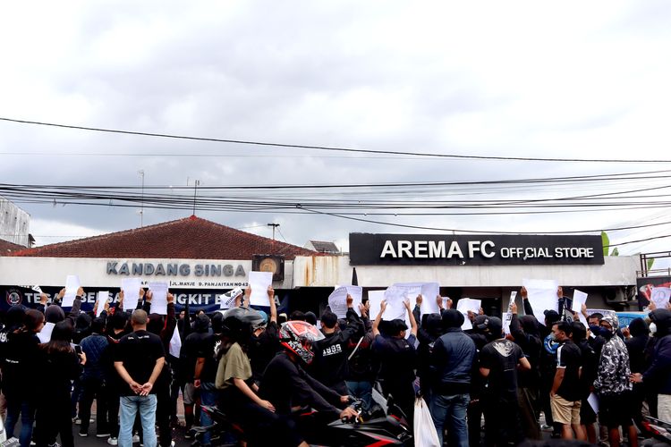 Puluhan suporter Arema, Aremania dan masyarakat melakukan aksi damai terkait Tragedi Kanjuruhan 1 Oktober lalu yang ditujukan kepada manajemen PT Arema Aremania Bersatu Berprestasi Indonesia di depan Kantor Arema FC Malang, Minggu (15/1/2023) siang.