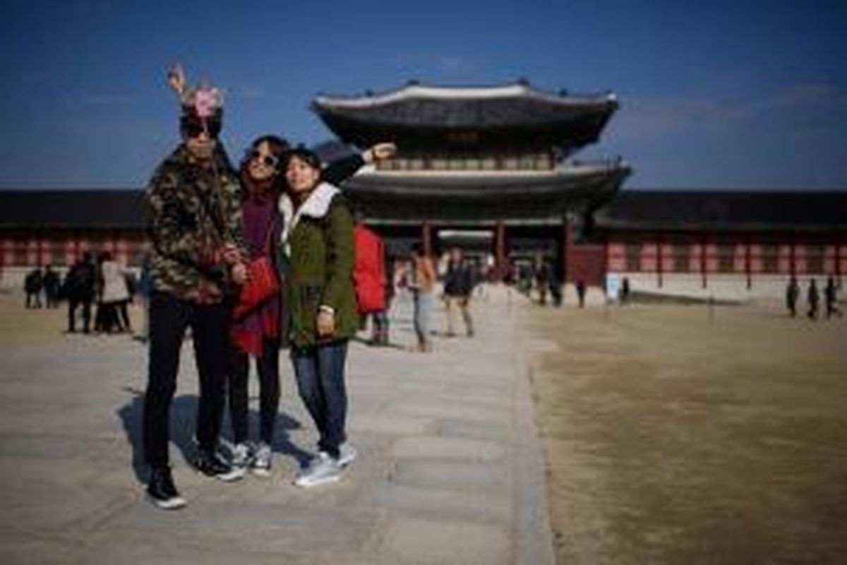 Wisatawan berfoto menggunakan tongkat narsis (tongsis) di salah satu kawasan wisata, di Seoul, Korea Selatan, 26 November 2014. Tongsis yang dijual dan beredar di negara K-pop tersebut diwajibkan melalui sertifikasi khusus.