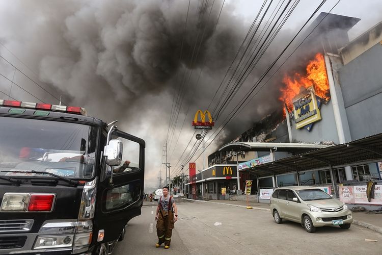 Api berkorbar dari sebuah pusat perbelanjaan di kota Davao, Filipina, Sabtu (23/12/2017). Puluhan orang dikhawatirkan menjadi korban tewas dalam kebakaran tersebut.
