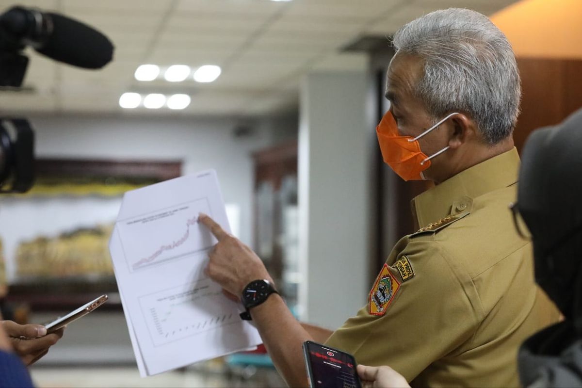 Gubernur Jawa Tengah (Jateng) Ganjar Pranowo menunjukkan grafik penurunan kasus Covid-19 kepada para awak media saat menghadiri Rapat Koordinasi (Rakor) Percepatan Penanganan Covid-19 di Lantai 2 Kantor Sekretariat Daerah (Setda) Provinsi Jateng, Senin (15/2/2021).