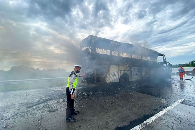 Petugas mengamati bus bernopol K 1670 EW yang terbakar di Tol Pandaan Pasuruan KM 60-800, Jawa Timur, Minggu (6/3/2022). Tidak ada korban jiwa dalam peristiwa tersebut dan penyebabnya masih dalam penyelidikan pihak berwajib.