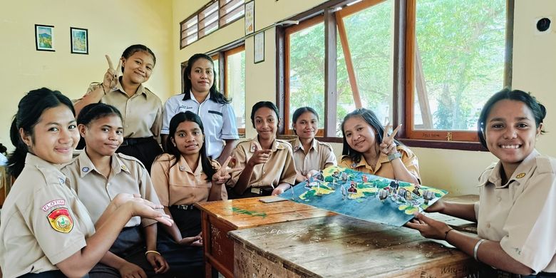 Elisabet Sabu Sogen (33) guru Sejarah di Sekolah Menengah Atas (SMA) Negeri 1 Adonara Barat, Kabupaten Flores Timur, Nusa Tenggara Timur (NTT), bersama siswa-siswinya dalam kegiatan pembelajaran materi dengan menggunakan media grafis  bekas.