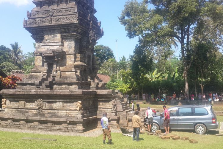 Petugas dibantu warga saat berusaha mengevakuasi mobil yang menabrak Candi Kidal, Kabupaten Malang, Selasa (25/7/2017)