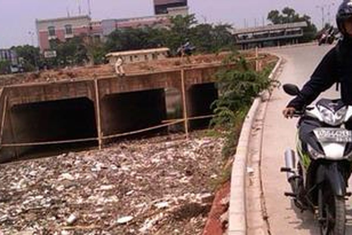 Seorang warga tengah melintas di Kali Bojong, Pondok Kelapa, Duren Sawit, Jakarta Timur, Rabu (31/10/2012). Kali yang terhubung dengan Kali Malang dengan Kanal Banjir Timur (KBT) itu tampak memprihatinkan dengan kondisi timbunan sampah.