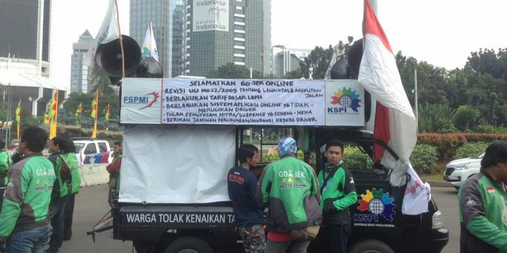Ratusan pengemudi ojek online berkumpul di samping ruas Jalan Medan Merdeka Barat, Jakarta Pusat, untuk kemudian berunjuk rasa ke depan Kementerian Perhubungan (Kemenhub) dan Istana Negara, Senin (15/5/2017).