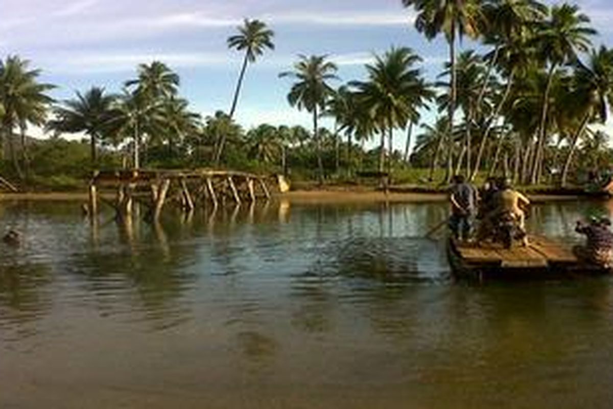 Warga menumpangi rakit untuk menyeberangi sebuah sungai di Kecamatan Molawe, Kabupaten Konawe Utara, Sulawesi Tenggara, Selasa (25/10/2011). Jembatan penghubung antardesa di kecamatan itu telah putus selama setahun terakhir akibat kerap dilewati angkutan berat, di antaranya truk-truk perusahaan tambang nikel yang beroperasi di sana.