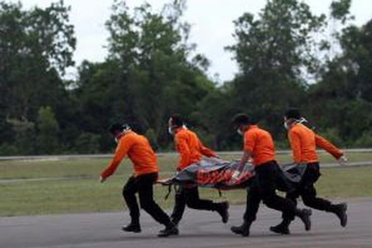 Petugas Basarnas membawa jenazah dari helikopter menuju ambulans di Posko Utama Pecarian Pesawat AirAsia QZ8501, Lanud Iskandar, Pangkalan Bun, Kalteng, Rabu (31/12/2014). Dua dari tujuh jenazah yang telah ditemukan dibawa ke posko untuk kemudian diidentifikasi di RSUD Sultan Imanudin.