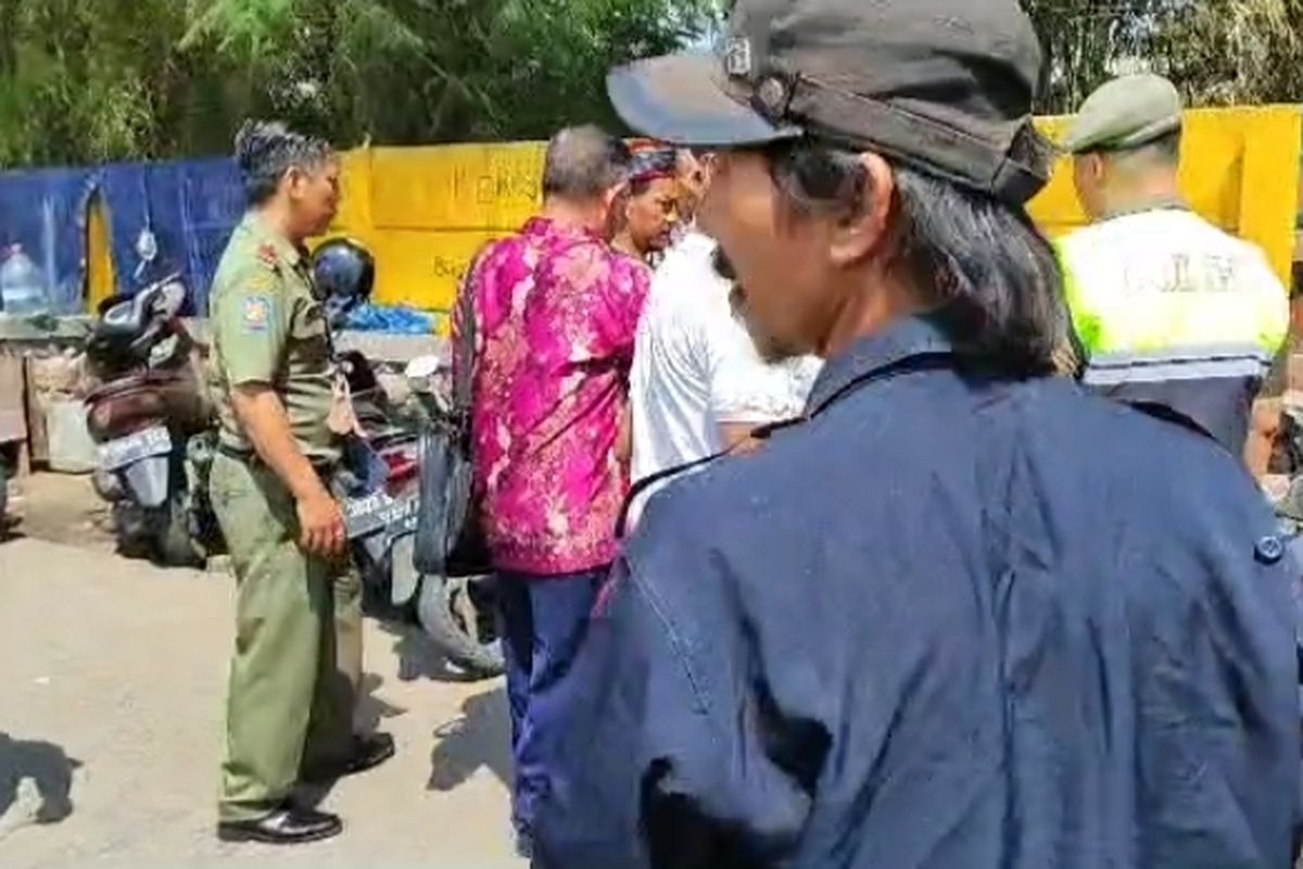 Warga dan anggota ormas menlarang awak media untuk meliput di permukiman di bawah kolong Jalan Tol Cawang-Tomang-Pluit Kilometer 17, Jelambar Baru, Jakarta Barat, Selasa (20/6/2023). 