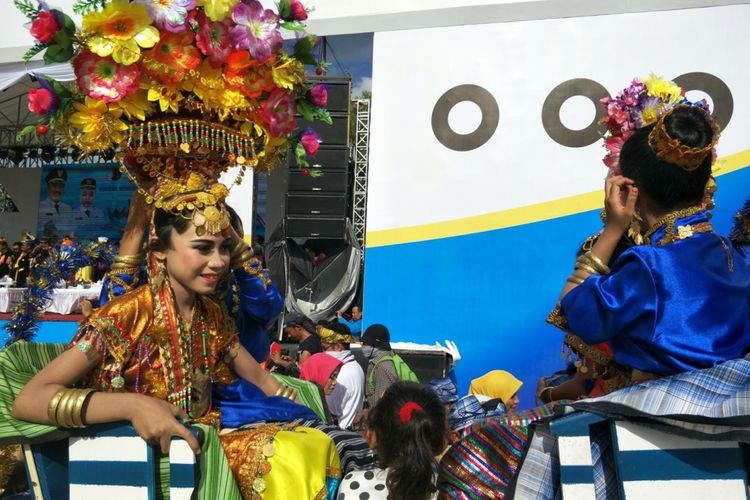 Anak perempuan Wakatobi saat mengikuti parade kebudayaan bahari, Wonderful Festival and Expo 2017 atau Wakatobi Wave 2017 di Pelabuhan Panggulubelo, Pulau Wangi-wangi, Kabupaten Wakatobi, Provinsi Sulawesi Tenggara, Sabtu (11/11/2017). Dia memakai pakaian adat lengkap dengan hiasan kepala dari bunga dan aksesoris adat berwarna emas, persis seperti mahkota putri kerajaan.