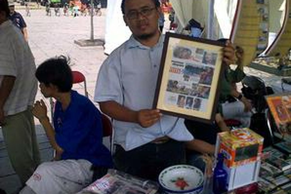 Ketua Komunitas Djadoel Daniel Supriyono sedang menunjukkan iklan film antik yang dijual Rp. 50 ribu dalam kesempatan Atraksi Kota Tua di Taman Fatahillah Jakarta, Minggu (15/11).
