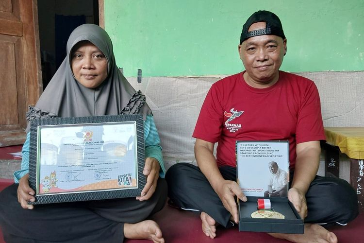 Erliyansah dan Dewi Rochana saat menunjukan piagam serta medali yang diraih oleh putri mereka Herfesa Shafira Devi.