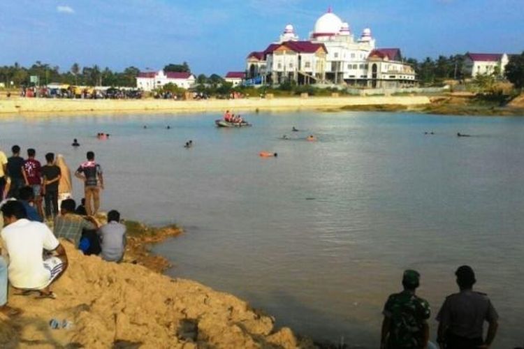 Masyarakat menyaksikan pencarian korban tenggelam dalam waduk buatan di kompleks Pemerintah Aceh Timur, Sabtu (11/3/2017)