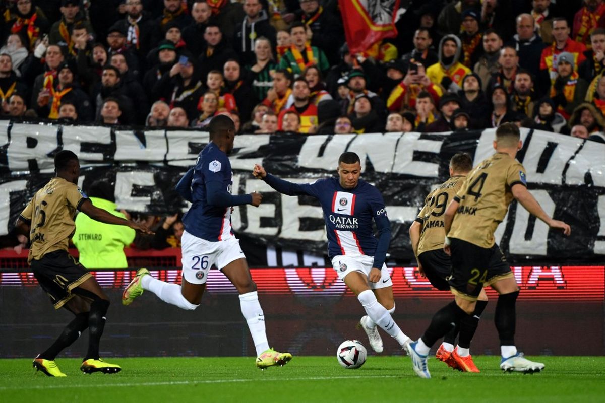 Kylian Mbappe saat mengolah bola dalam pertandingan Lens vs PSG pada pekan ke-17 Liga Perancis 2022-2023 di Stade Bollaert-Delelis, Senin (2/1/2023) dini hari WIB. Laga Lens vs PSG berakhir dengan skor 3-1. (Foto oleh FRANCOIS LO PRESTI / AFP)
