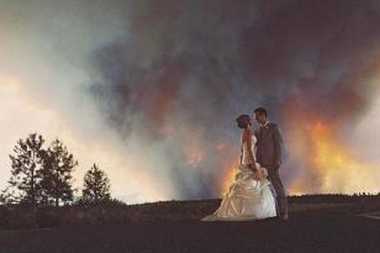Pasangan April Hartley dan Michael Wolber diambil fotonya dengan latar belakang api yang menjilati hutan tak jauh dari lokasi pesta pernikahan mereka.