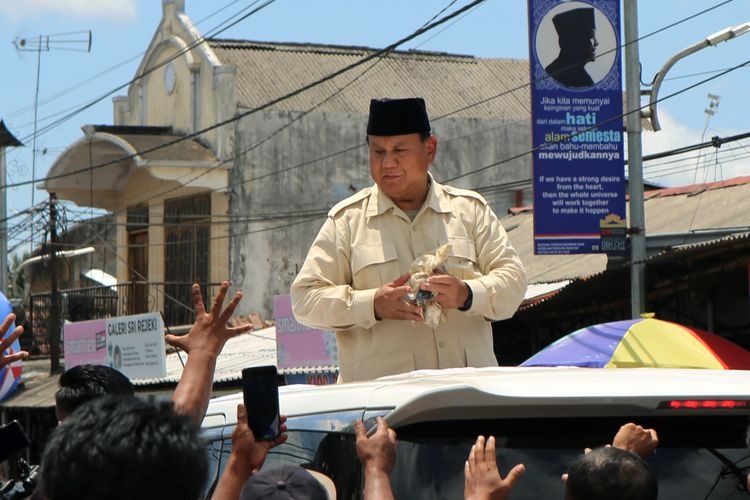 Capres Nomor urut 2 Prabowo Subianto membagikan kaos kepada masyarakat usai berziarah ke Makam Presiden Soekarno di Blitar, Jawa Timur, MInggu (17/12/2023). Selain berziarah, Prabowo juga melakukan deklarasi dengan gerakan masyarakat perhutanan sosial indonesia di GOR Soekarno-Hatta.