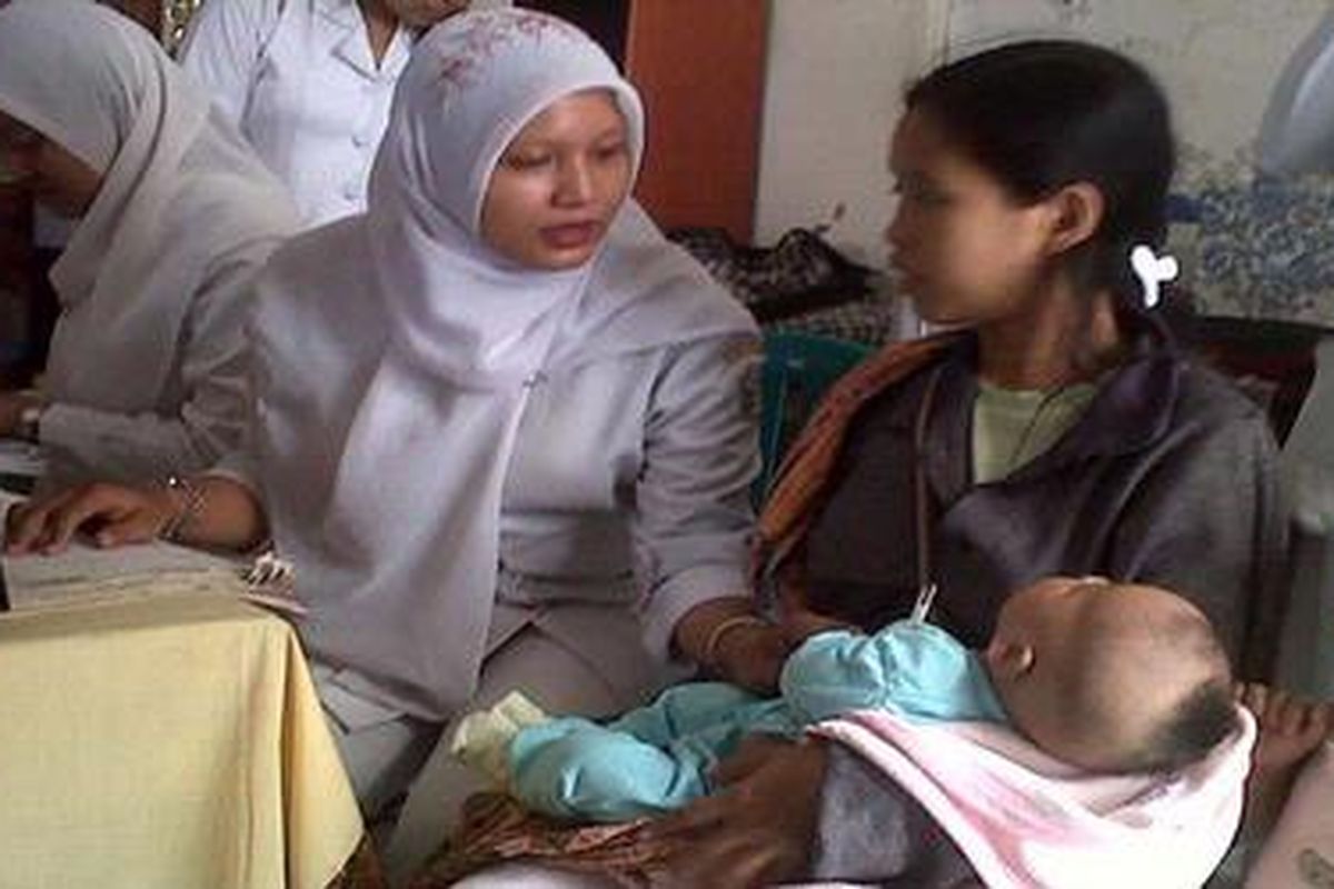 Seorang balita tengah diperiksa sebelum mendapat imunisasi difteri di Kelurahan Simokerto, Kecamatan Simokerto, Kota Surabaya, Senin (10/10/2011).