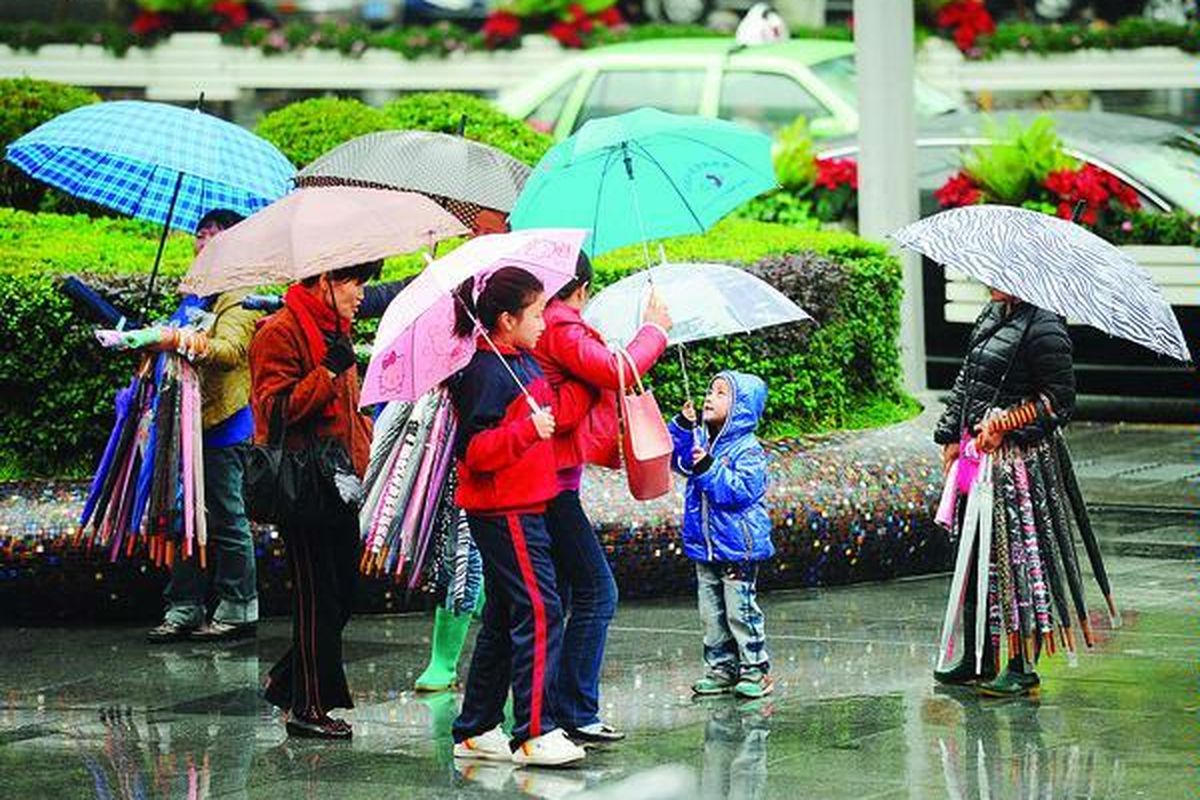 Penjual payung menjajakan dagangannya di tepi jalan di Shanghai China, Jumat (9/11). Laju inflasi China pada Oktober melambat, terendah dalam tiga tahun, yang membuka peluang bagi pemerintah untuk mengeluarkan stimulus ekonomi.