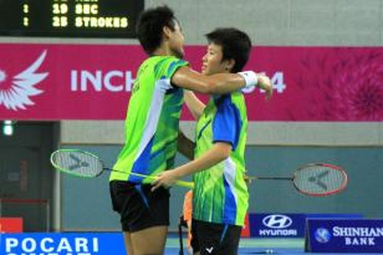 Pasangan ganda campuran Indonesia, Tontowi Ahmad (kiri)/Liliyana Natsir, berpelukan setelah memenangi laga semfinal Asian Games 2014 melawan ganda Tiongkok, Xu Chen/Ma Jin, di Incheon, Korea Selatan, Minggu (28/9/2014).