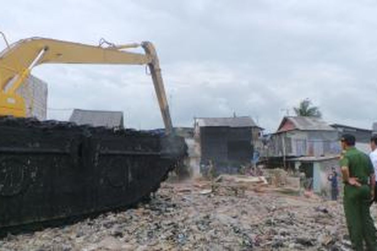 Bangunan di tepi Waduk Pluit, Penjaringan, Jakarta Utara, dibongkar petugas dengan alat berat. Senin (23/2/2015).