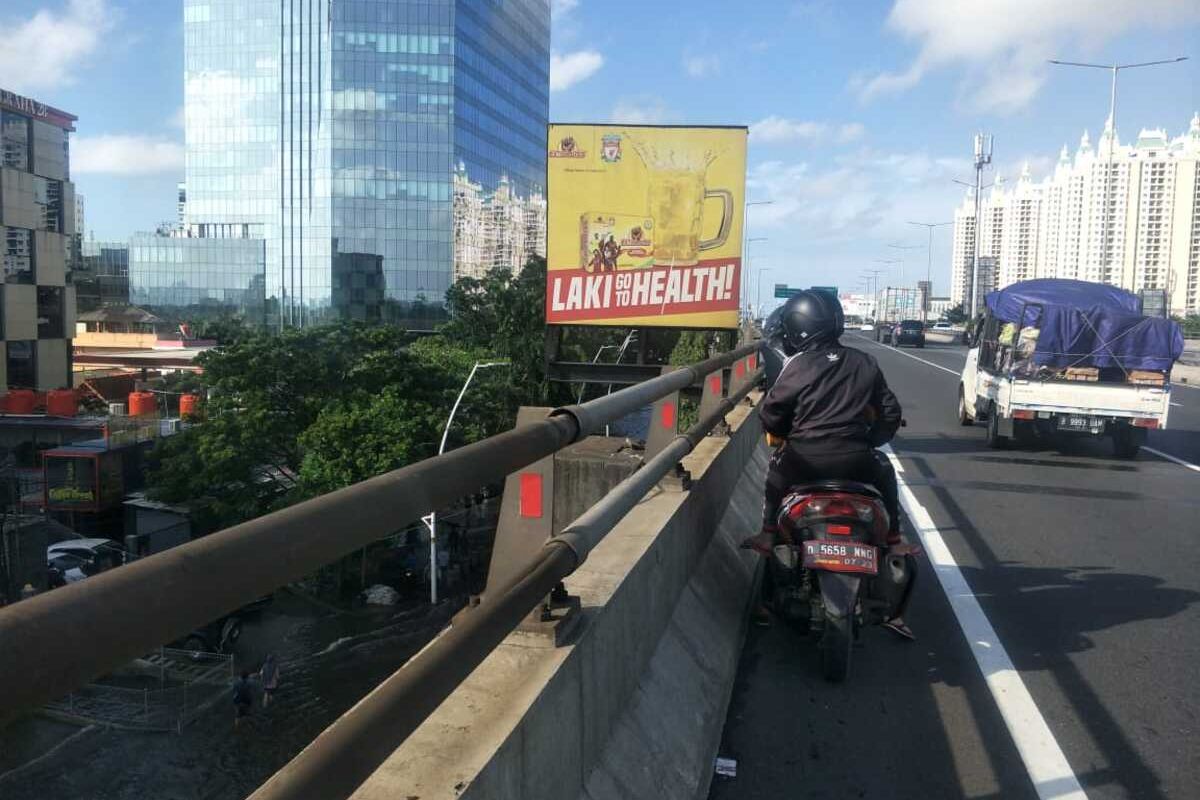 Pengendara sepeda motor yang masuk Jalan Tol Wiyoto Wiyono demi menghindari banjir Jalan Yos Sudarso, Jakarta Utara, Minggu (23/2/2020)