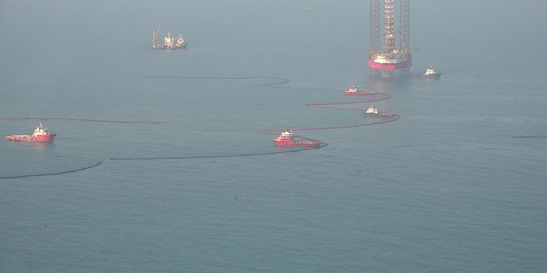 Static boom dan kapal combat milih PHE ONWJ yang bekerja membersihkan tumpahan minyak di laut