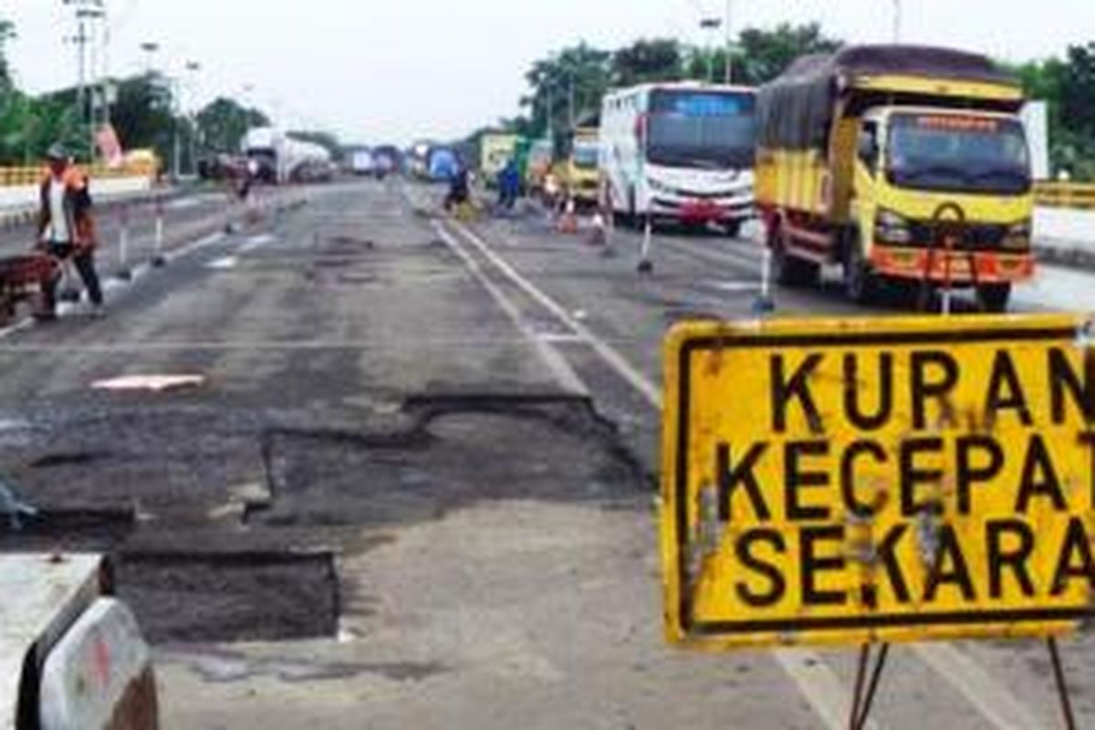 Sejumlah pekerja tengah memperbaiki jalan rusak di Jembatan Elon, Kabupaten Pemalang, Selasa (28/1/2014). Jalan rusak tak hanya terdapat di sepanjang jalan Pantura Barat. Namun, di sejumlah jembatan pun terdapat aspal yang mengelupas. 