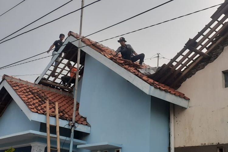 Sejumlah warga dibantu petugas BPBD memperbaiki atap rumah yang rusak akibat hujan deras disertai angin kencang di wilayah Kecamatan Margadana, Kota Tegal, Jawa Tengah, Sabtu (8/10/2022).