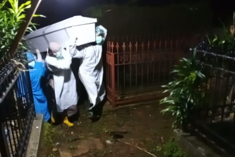 DIMAKAMKAN PROKES--Tim satgas memakamkan jenazah secara protokol kesehatan di tempat pemakaman umum di Desa Watusomo, Kecamatan Slogohimo, Kabupaten Wonogiri, Jawa Tengah, Rabu (9/2/2022) malam. 