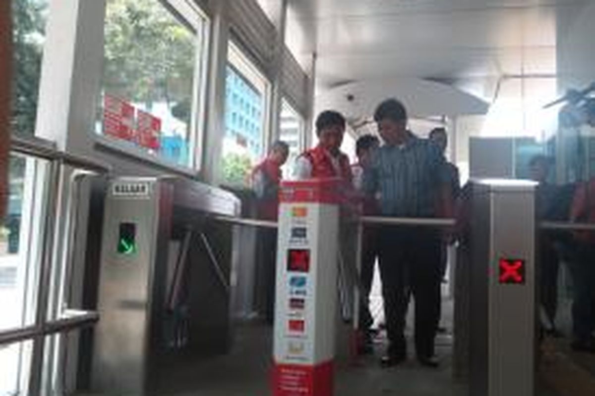 Salah seorang penumpang transjakarta hendak melewati pintu elektronik, di Halte Karet, Senin (11/8/2014) 