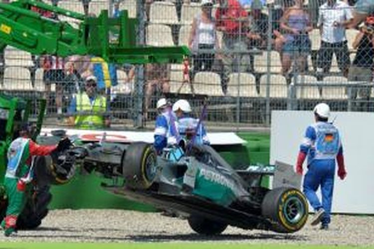 Mobil Mercedes yang dikendarai pebalap Inggris, Lewis Hamilton, diangkat dari lintasan setelah kecelakaan yang terjadi pada kualifikasi pertama GP Jerman di Sirkuit Hockenheim, Sabtu (19/7/2014).