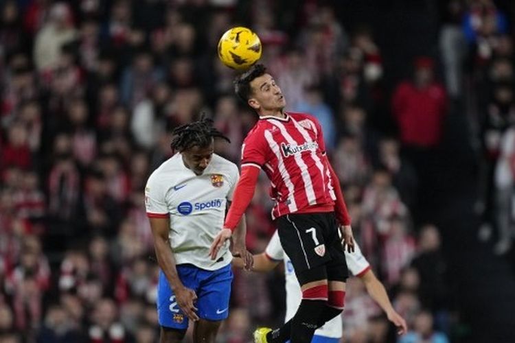 Winger Athletic Bilbao, Alex Berenguer, berebut bola dengan bek tengan Barcelona, Jules Kounde, pada pertandingan La Liga di Stadion San Mames, Minggu (3/3/2024) atau Senin dini hari WIB.  