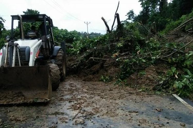 Sebuah alat berat menyingkirkan material longsor di jalan penghubung Provinsi Gorontalo dan Sulawesi Tengah bagian utara, Jumat (27/1/2017).